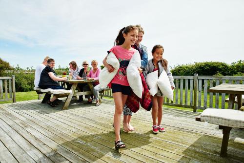two girls are walking on a deck with towels at Hostel Agger Vandrerhjem in Agger