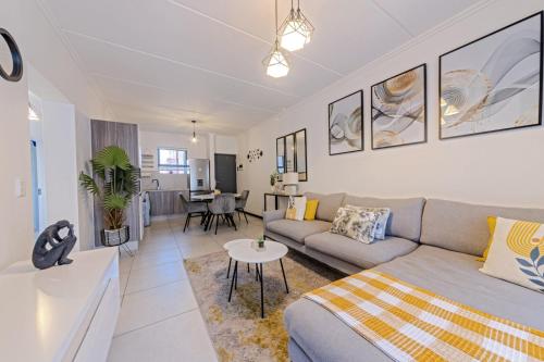 a living room with a couch and a table at Bloom Modern Apartment in Fourways