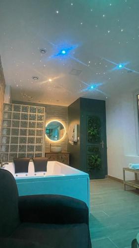 a room with a tub in a room with blue lights at Suite Yao avec jacuzzi Montataire YaoSpa60 in Thiverny
