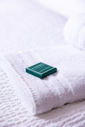 a green book sitting on top of a white bed at L'Auberge de Mens in Mens