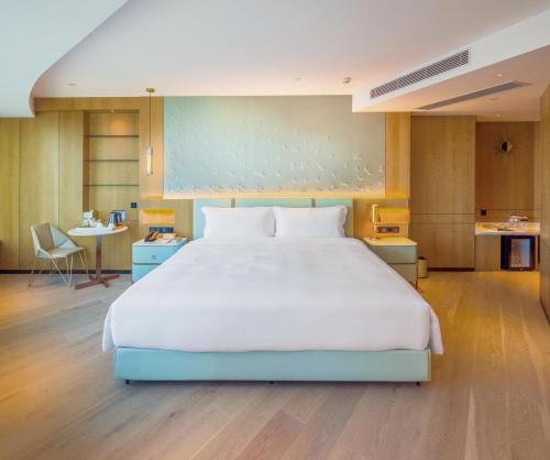 a large white bed in a large room at YOHO Treasure Island Hotel in Macau
