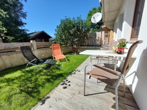 a patio with chairs and a table in the grass at Ferienwohnung Gstreinthaler in Tulfes
