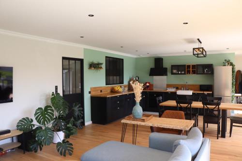 a living room with a kitchen and a dining room at Maison proche zoo de la Flèche et circuit 24h in La Chapelle-dʼAligné