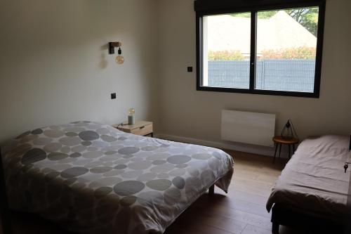 a bedroom with a bed and a window at Maison proche zoo de la Flèche et circuit 24h in La Chapelle-dʼAligné