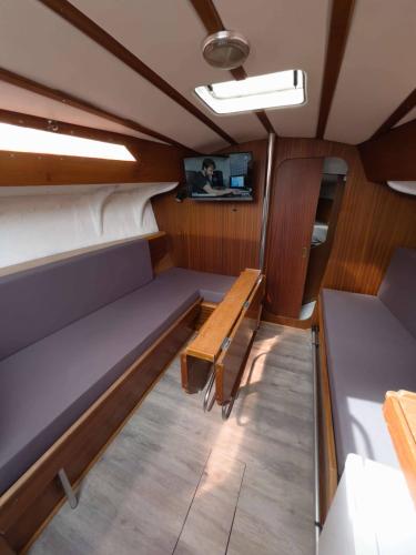 - un petit bateau avec un banc et une télévision dans l'établissement Voilier Aix les bains, à Brison-Saint-Innocent
