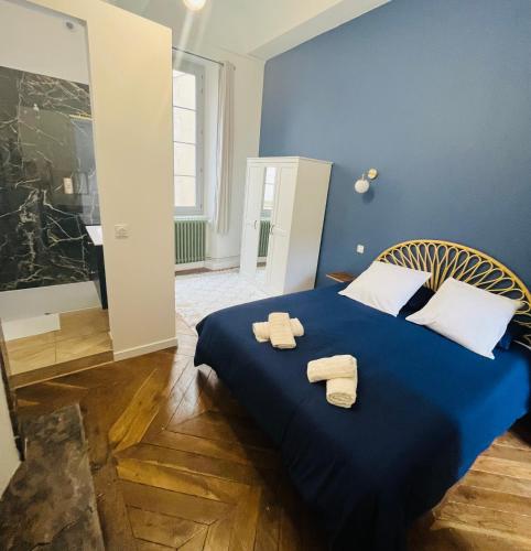 - une chambre bleue avec 2 serviettes sur un lit dans l'établissement Luxueux appartement cosy, hypercentre Castres, à Castres