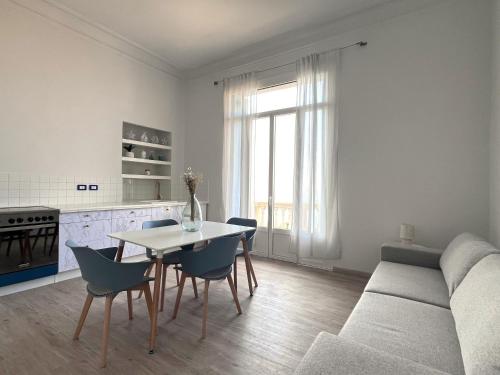 un salon avec un canapé, une table et des chaises dans l'établissement Appartamento Elegante in Villa Storica sul Mare, à Garavan