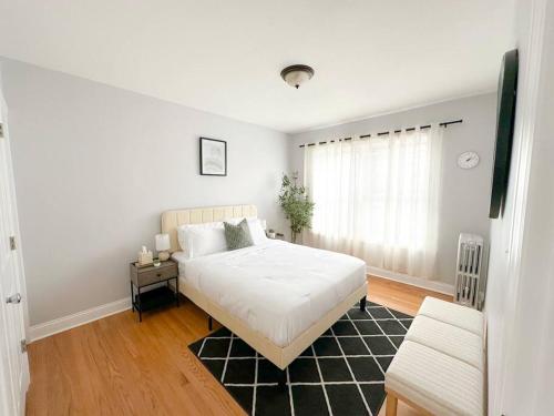 a bedroom with a white bed and a black rug at Cozy Retreat, Prime Location Near Loyola & Beach! in Chicago