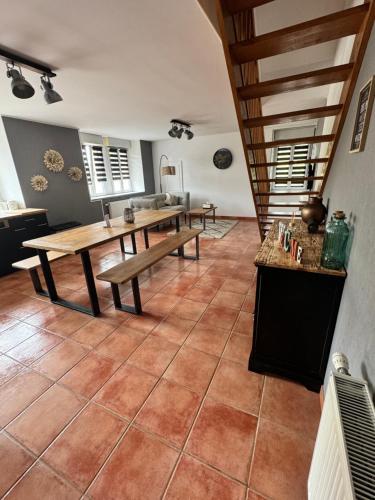 a large room with a table and benches in it at Maison aux pieds du circuit de Mirecourt in Baudricourt