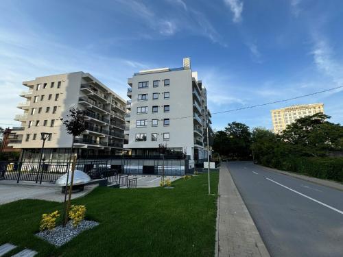 two tall white buildings next to a street at Luxury Studios at Unique opposite Palas with Parking in Iaşi