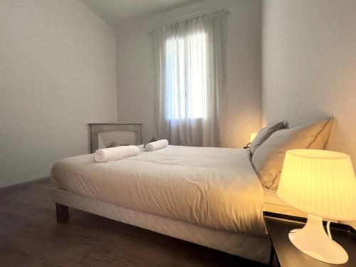 une chambre avec un lit avec une lampe et une fenêtre dans l'établissement Appartamento Elegante in Villa Storica sul Mare, à Garavan