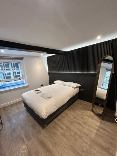 a bedroom with a large bed with a mirror at 10 Hockenhall - Liverpool's Oldest House in Liverpool