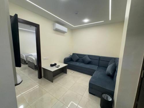 a living room with a blue couch and a mirror at Golden Light Aqaba Hotel فندق جولدن لايت العقبة in Aqaba