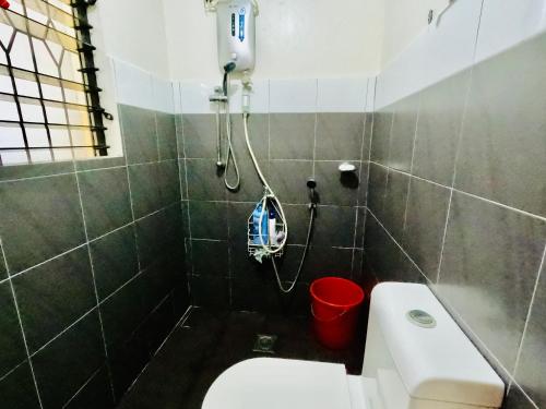a bathroom with a shower and a white toilet at lion dive guest house in Basdiot