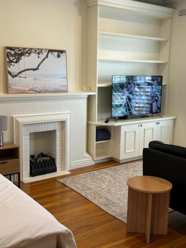 a living room with a fireplace and a flat screen tv at Regents Gate East Melbourne in Melbourne