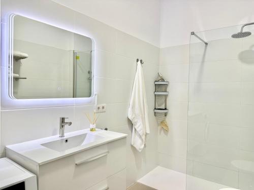 a white bathroom with a sink and a mirror at Luxury Apartment Tenerife in Adeje
