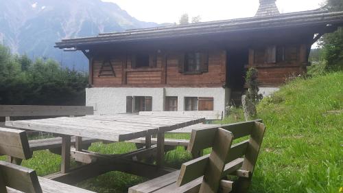 une table de pique-nique en bois devant un bâtiment dans l'établissement Résidence plein sud en vallée de Chamonix, aux Houches