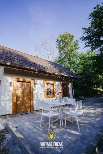 a white table and chairs in front of a building at Domki - Zajazd Zieleńska Polana in Wisła
