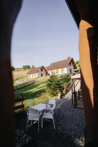 a table and chairs in a yard with a house at Domki - Zajazd Zieleńska Polana in Wisła