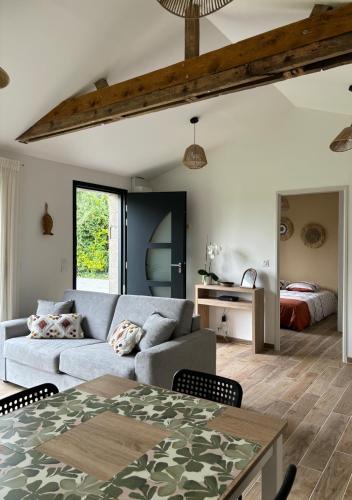 un salon avec un canapé et un lit dans l'établissement Maison entre campagne et mer, à Sainte-Marguerite