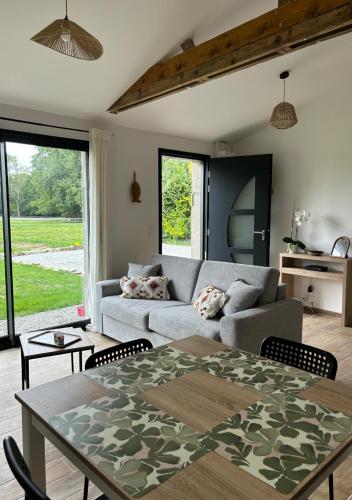 un salon avec un canapé et une table dans l'établissement Maison entre campagne et mer, à Sainte-Marguerite