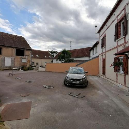 a car parked in a parking lot next to a building at LE COCOON / PROCHE GARE / NETFLIX in Sens