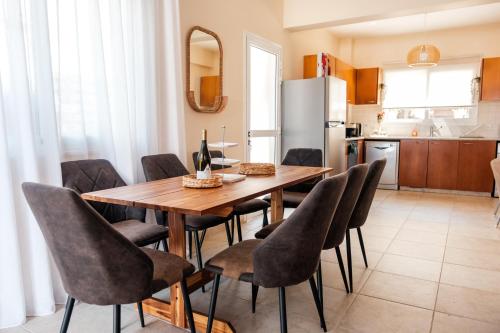 a kitchen and dining room with a wooden table and chairs at Mermaid Villa 16 in Ayia Napa