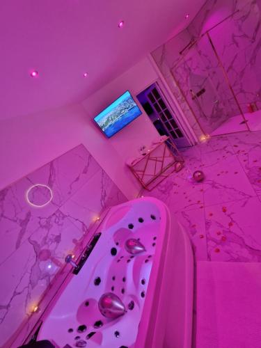 Cette chambre rose comprend une baignoire rose. dans l'établissement Maison Chic avec jacuzzi Nogent sur Oise YaoSpa60, à Nogent-sur-Oise
