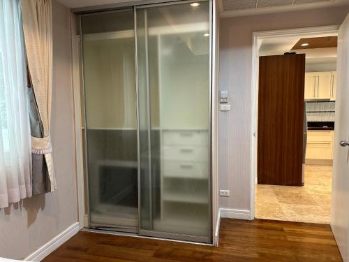 a glass shower door in a room with a kitchen at Bel Air Cape Panwa resort apartment in south Phuket with pool access ,near Ao Yon in Phuket Town