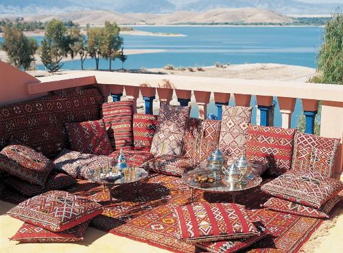 a group of pillows on a table on a balcony at Rive Du Lac in Lalla Takerkoust