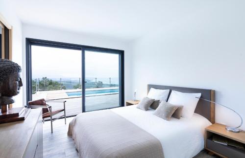 une chambre avec un grand lit et une grande fenêtre dans l'établissement a STELLA DI FOCE, à Kamiesch