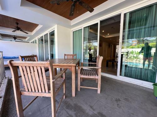 a wooden table and chairs on a patio at Bel Air Cape Panwa resort apartment in south Phuket with pool access ,near Ao Yon in Phuket