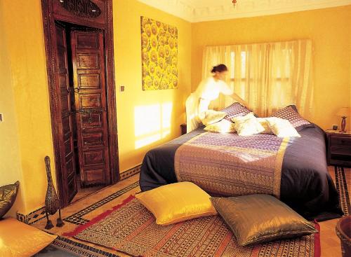 a woman is standing on a bed in a room at Rive Du Lac in Lalla Takerkoust