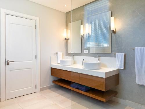 a bathroom with two sinks and a mirror at Blue Bird in Pereybere