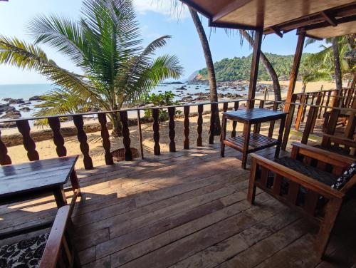 パテンムにあるColomb Beach Hutsのビーチを望むウッドデッキ(ベンチ付)