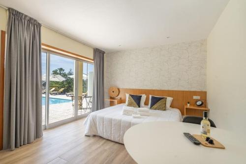 ein Schlafzimmer mit einem Bett und einem Pool in der Unterkunft Casa da Naia in Adaúfe