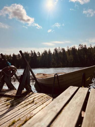 a man sitting in a boat at a dock at Kyyronkaita in Mikkeli