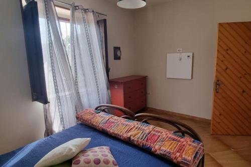 a bedroom with a blue bed and a window at Villa Panno, posto romantico! in Serre