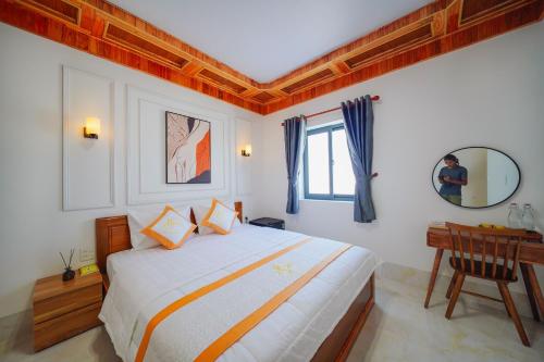 a bedroom with a bed and a desk and a mirror at BÌNH MINH HOTEL - ĐẢO PHÚ QUÝ in Cu Lao Thu