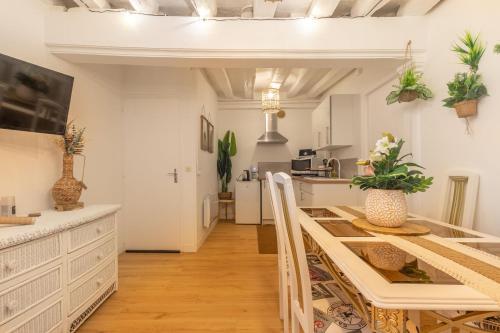 Una cocina y un comedor con mesa y sillas. en Coucher Bohème, en Orléans