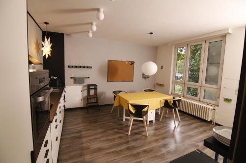 a kitchen and dining room with a yellow table and chairs at Large 120m apartment with garden and cat near ZOO in Prague