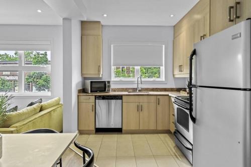 a kitchen with a white refrigerator and a table at Stylish 2 Bedroom Haven by Jean Talon Market in Montréal