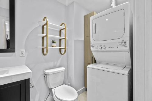 a white bathroom with a toilet and a sink at Stylish 2 Bedroom Haven by Jean Talon Market in Montréal
