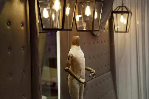 a figurine of a person standing in a hallway with lights at Hotel La Lanterne & Spa By Timhotel in Paris