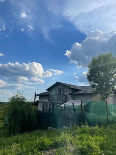 a house in a field with a fence at Cabana Talea Residence Prahova in Plaiu