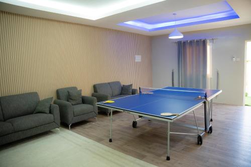 a room with a ping pong table and chairs at Hatta Orchard in Hatta