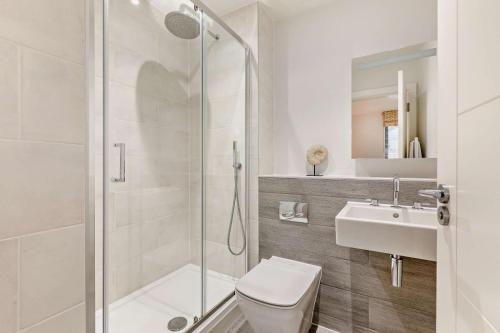 Un baño con ducha, inodoro y lavabo. en 3 Challacombe - Luxury Apartment at Byron Woolacombe, only 4 minute walk to Woolacombe Beach!, en Woolacombe