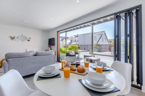 a white table and chairs in a living room at 1 Challacombe - Luxury Apartment at Byron Woolacombe, only 4 minute walk to Woolacombe Beach! in Woolacombe