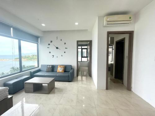 ニャチャンにあるNha Trang Beachfront Luxury Residenceのリビングルーム(青いソファ、壁掛け時計付)