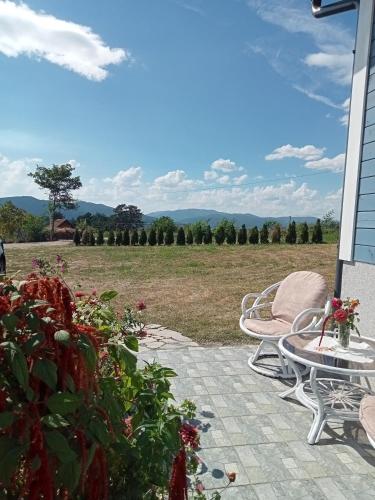 a patio with chairs and a view of a field at Vikendica Maša Blu in Šljivovica